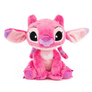 Pink plush toy creature with big black eyes, sitting and smiling at the camera.